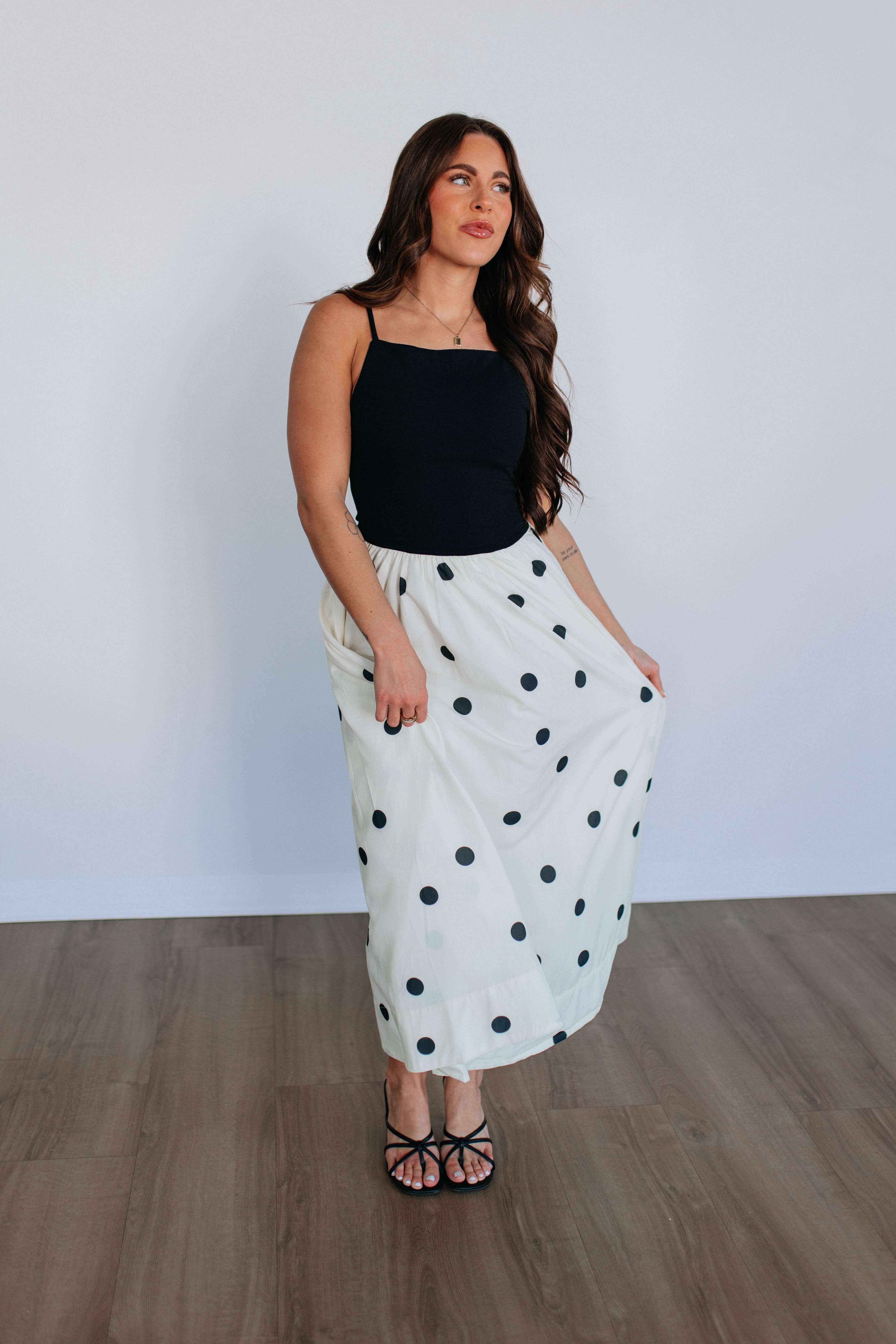 Beautiful model wearing a stylish polka dot skirt from the Skirts collection, showcasing modern fashion trends.